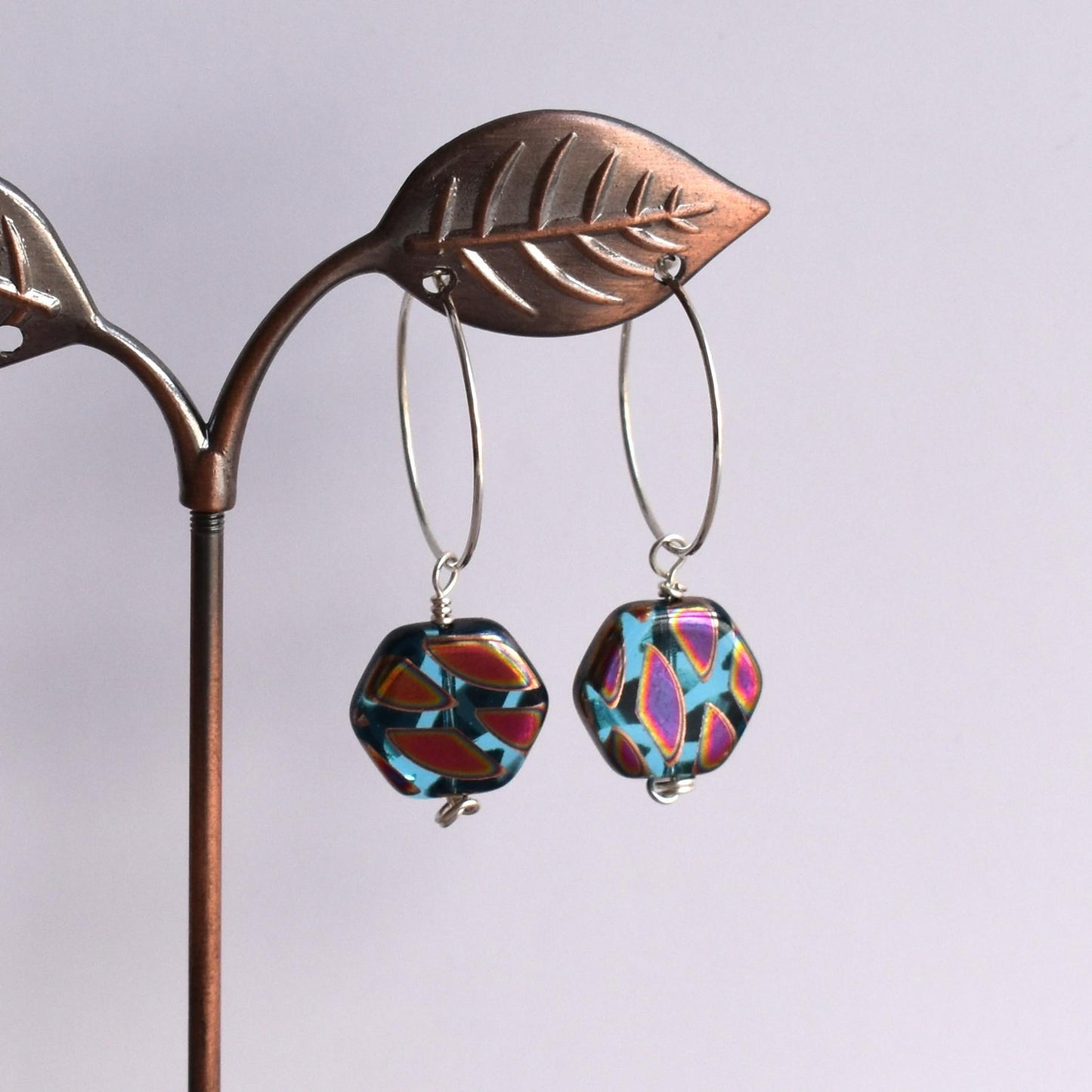 Silver hoop earrings with blue hexagon bead drop